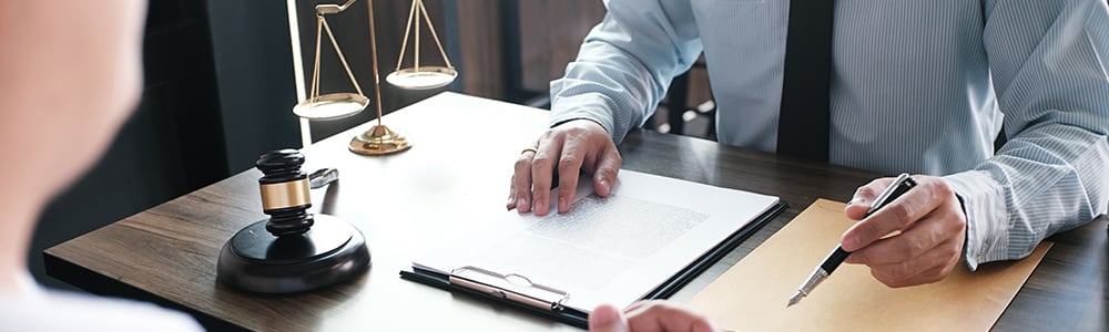 An attorney goes over legal paperwork with his client.