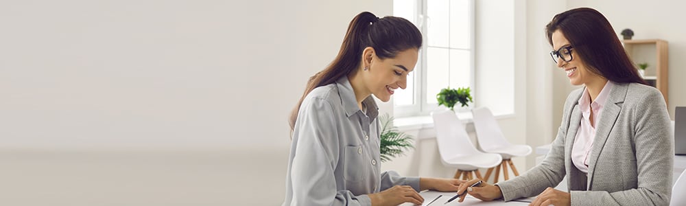 2 women discussing financial papers